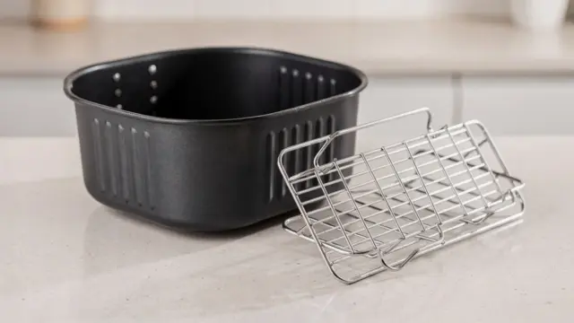 Gittereinsatz für die Heißluftfritteuse neben einem Korb auf der Küchenarbeitsfläche
